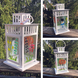 Four seasons fused glass lantern with candle.  Spring flowers, summer flowers, fall birch trees and a snowman.